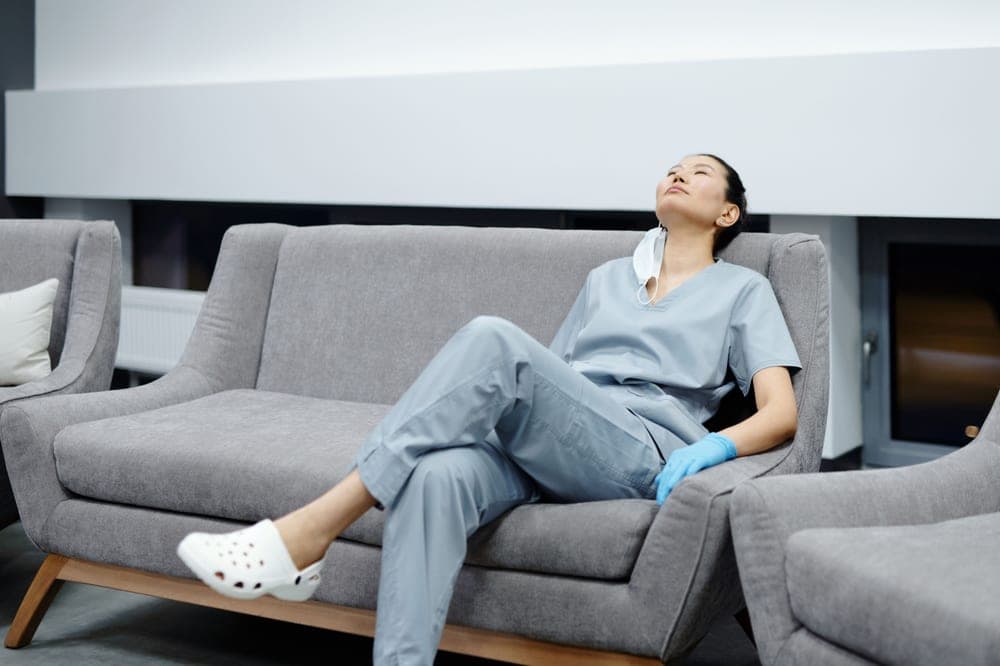 Tired worker in a quiet hospital corridor at night