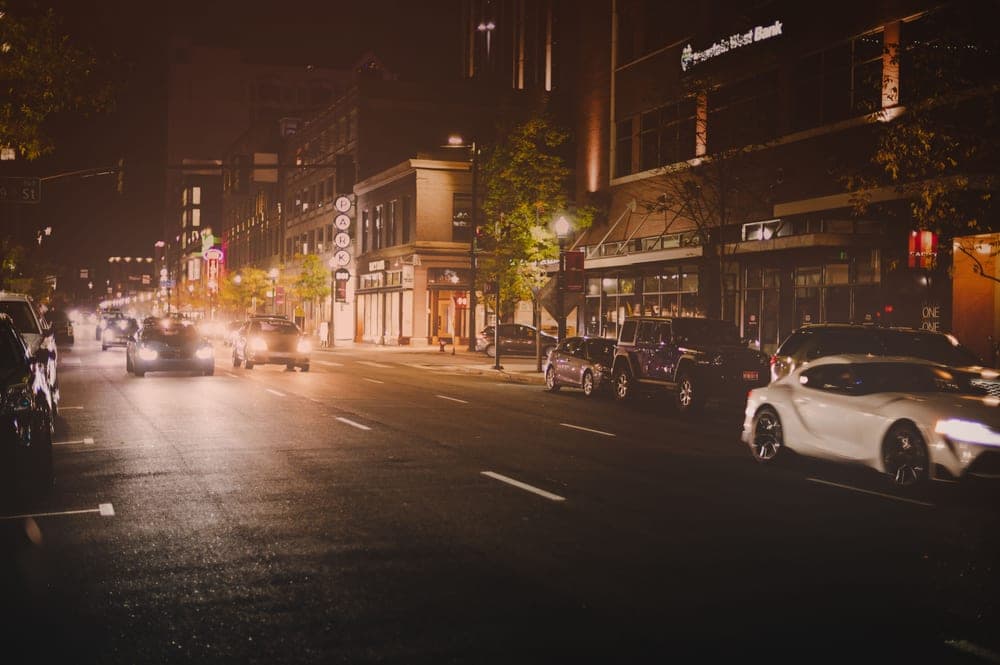 Traffic passing a residential apartment building at night