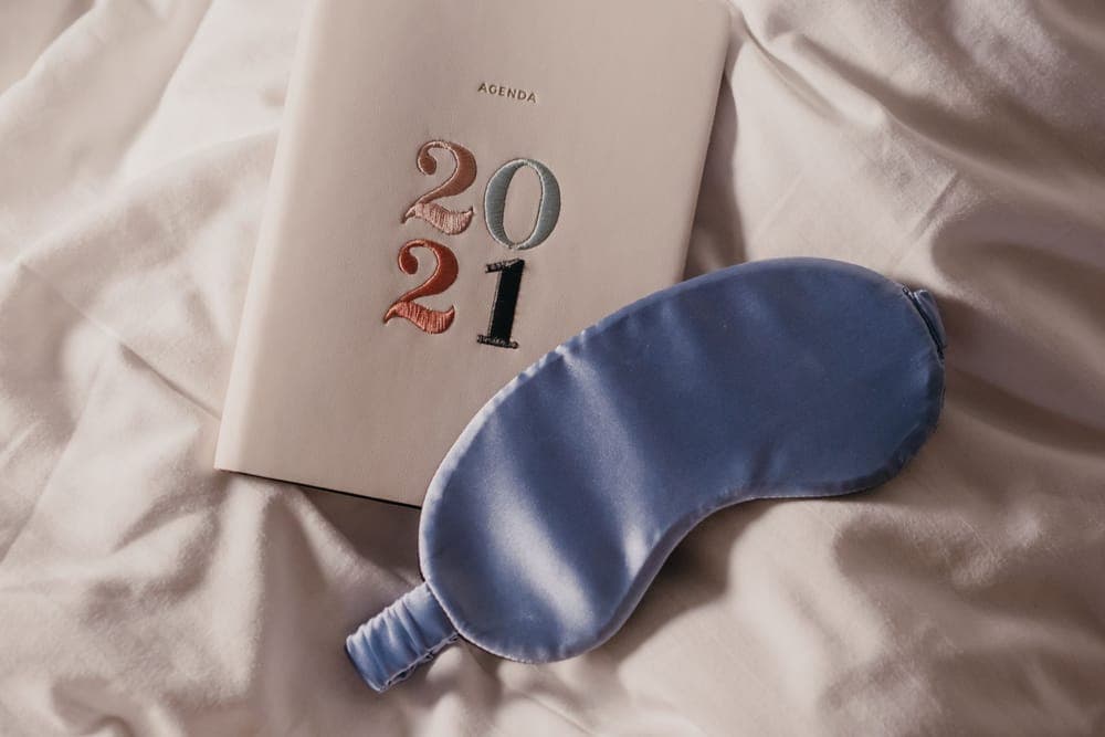 Soft eye mask resting on a bedside surface in low light