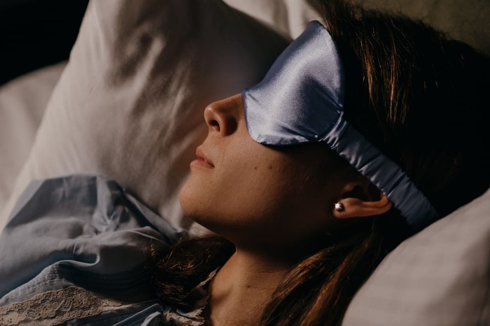 Side view of a sleeper wearing a soft eye mask - illustrative category image