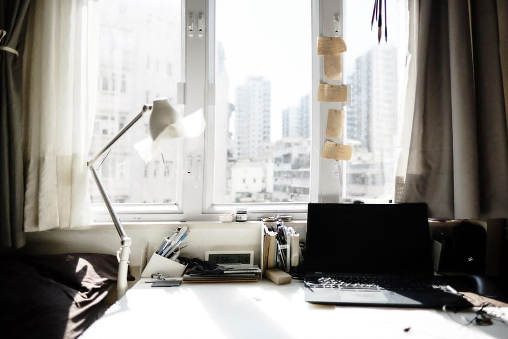 Bright daylight-style lamp on a desk beside a winter window