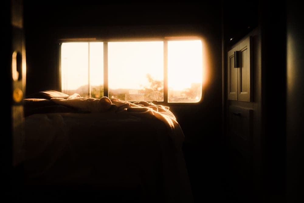 Soft golden morning light across a bedroom window