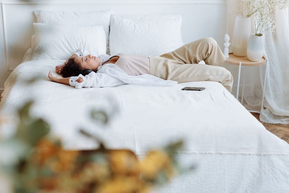Person lying in bed at night wearing headphones