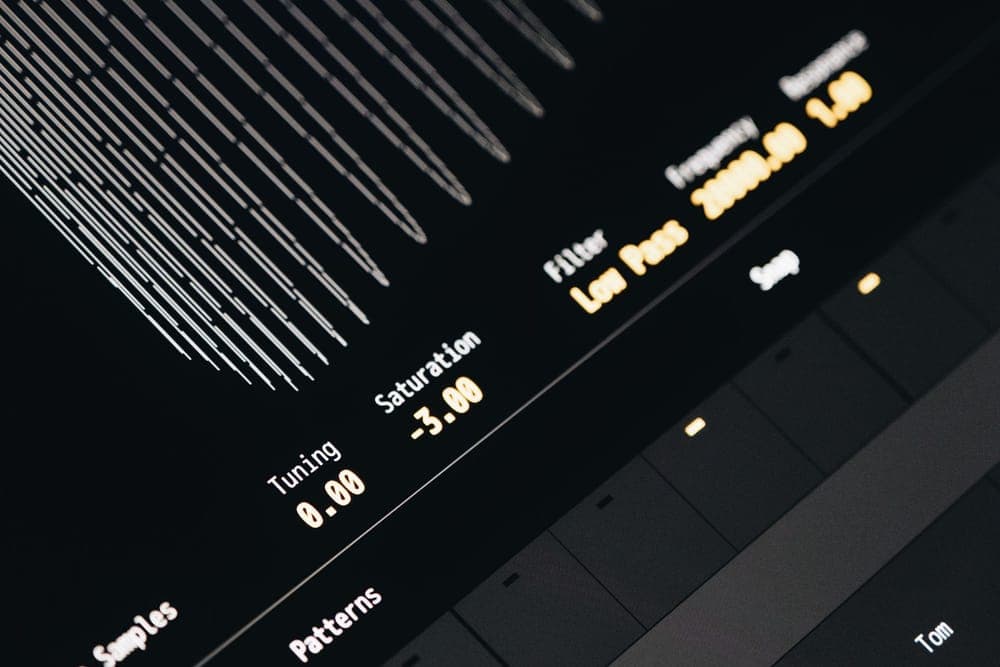 Close-up of an illuminated audio mixing surface in a dark room