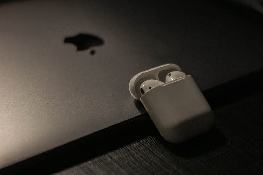 Wireless earbud charging case on a dark bedside surface - illustrative category image