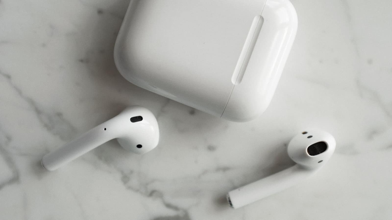 Wireless earbud charging case open on a dark tabletop