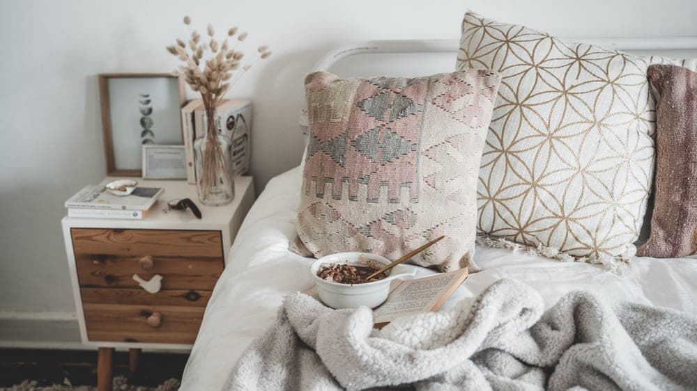 Calm neutral-toned bedroom with a soft knit throw across the bed