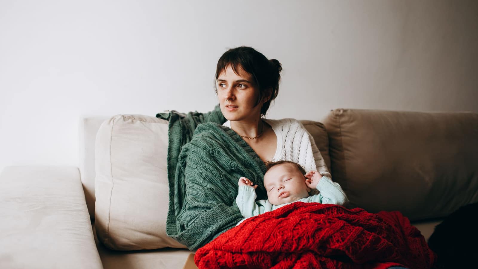 Child wrapped in a heavy folded blanket in a calm, softly lit room