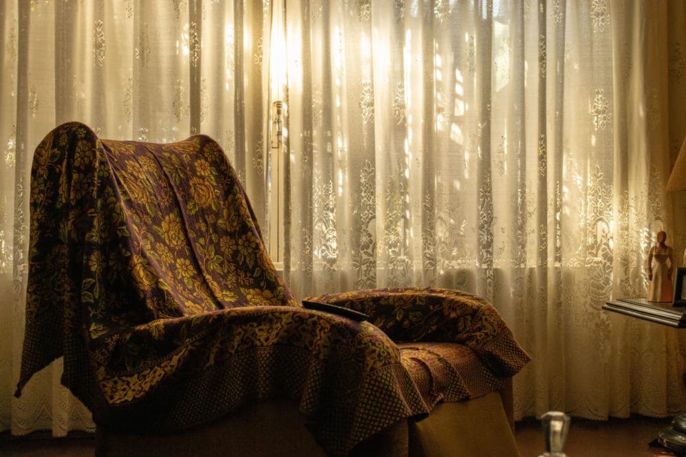 Soft blanket draped over an armchair beside a winter window