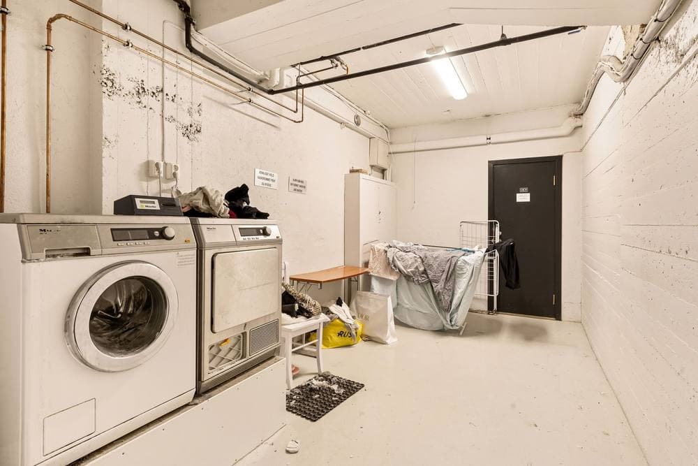 Laundry room with a washing machine and folded bedding - illustrative category image